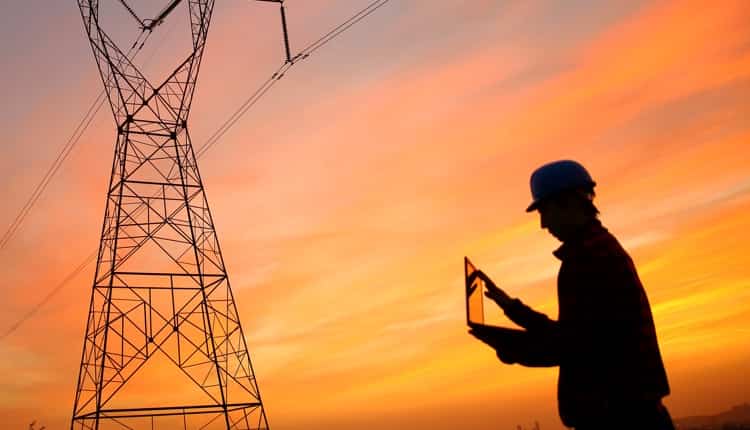 Person in front of power lines, looking at tablet