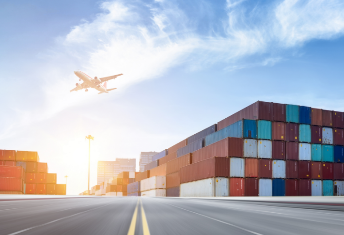 Airplane flying over shipping yard