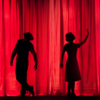 2 people in front of red curtain