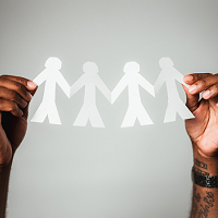 Hands holding paper people chain
